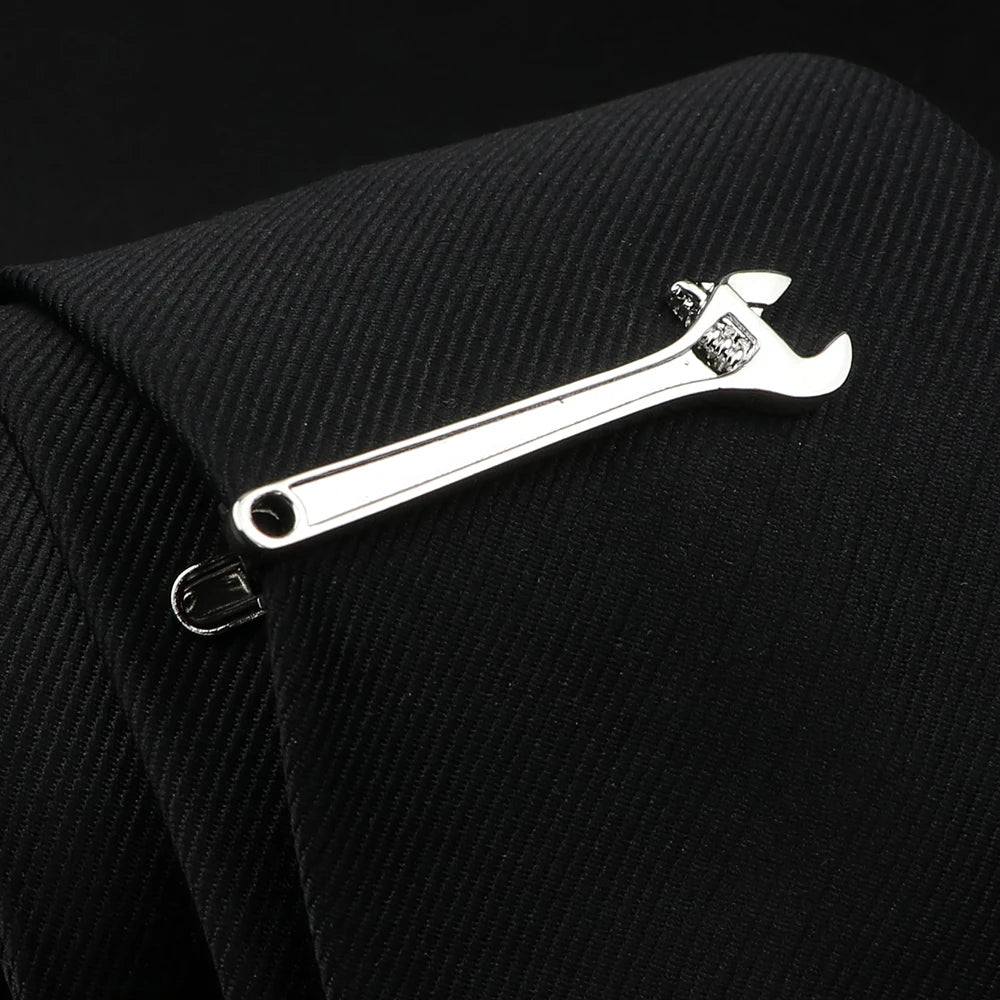 Metallic adjustable wrench keychain on a black textured background