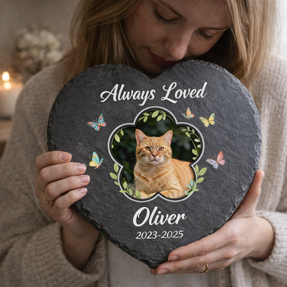 Person holding a heart-shaped slate with a cat's photo and 'Always Loved Oliver' text.