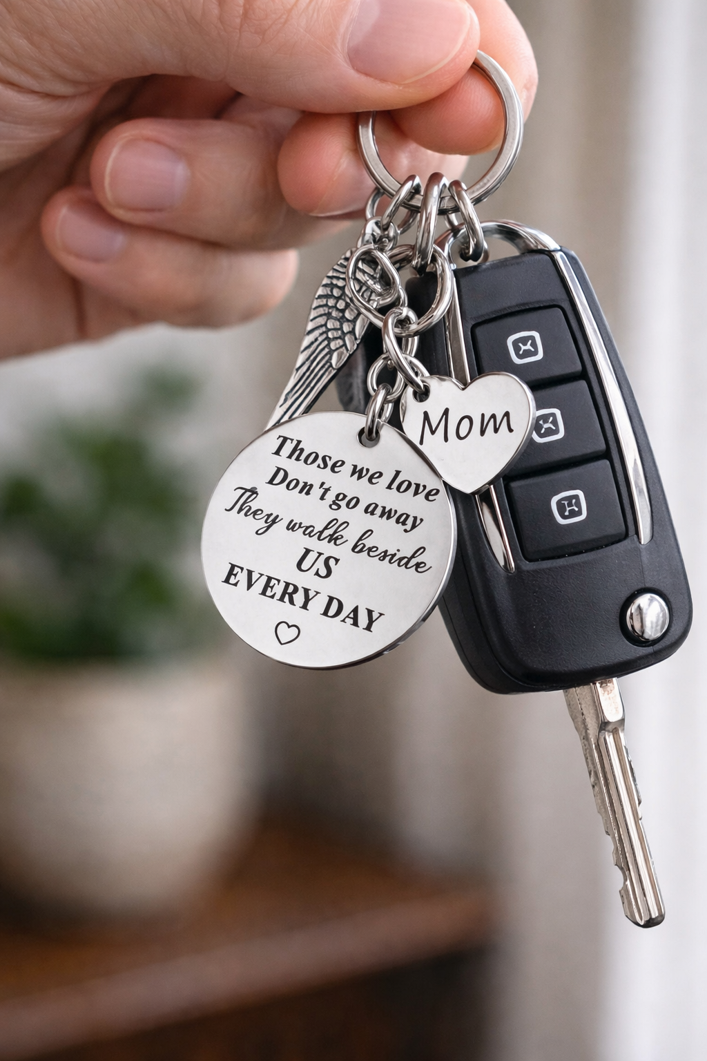 Keychain with engraved message held by a hand, with a blurred background
