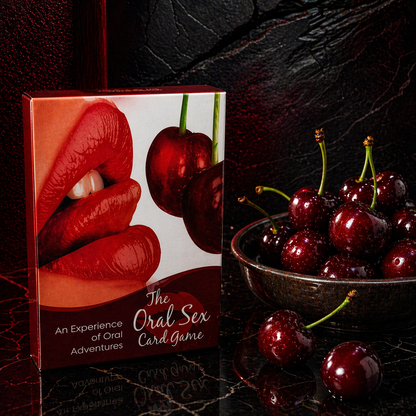 Card game box titled 'The Oral Sex Card Game' with cherries on a dark surface