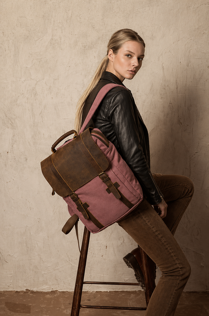Woman with a pink and brown backpack sitting on a stool against a beige wall.