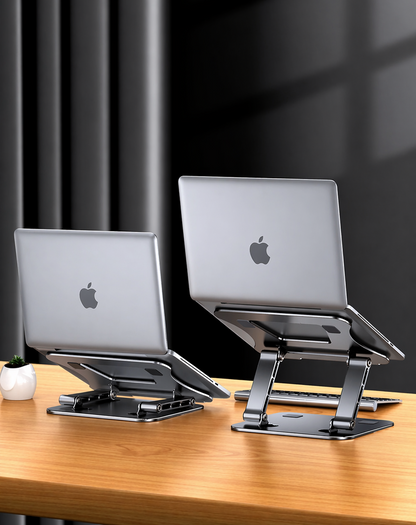 Two laptop stands with Apple laptops on a wooden surface against a black curtain background