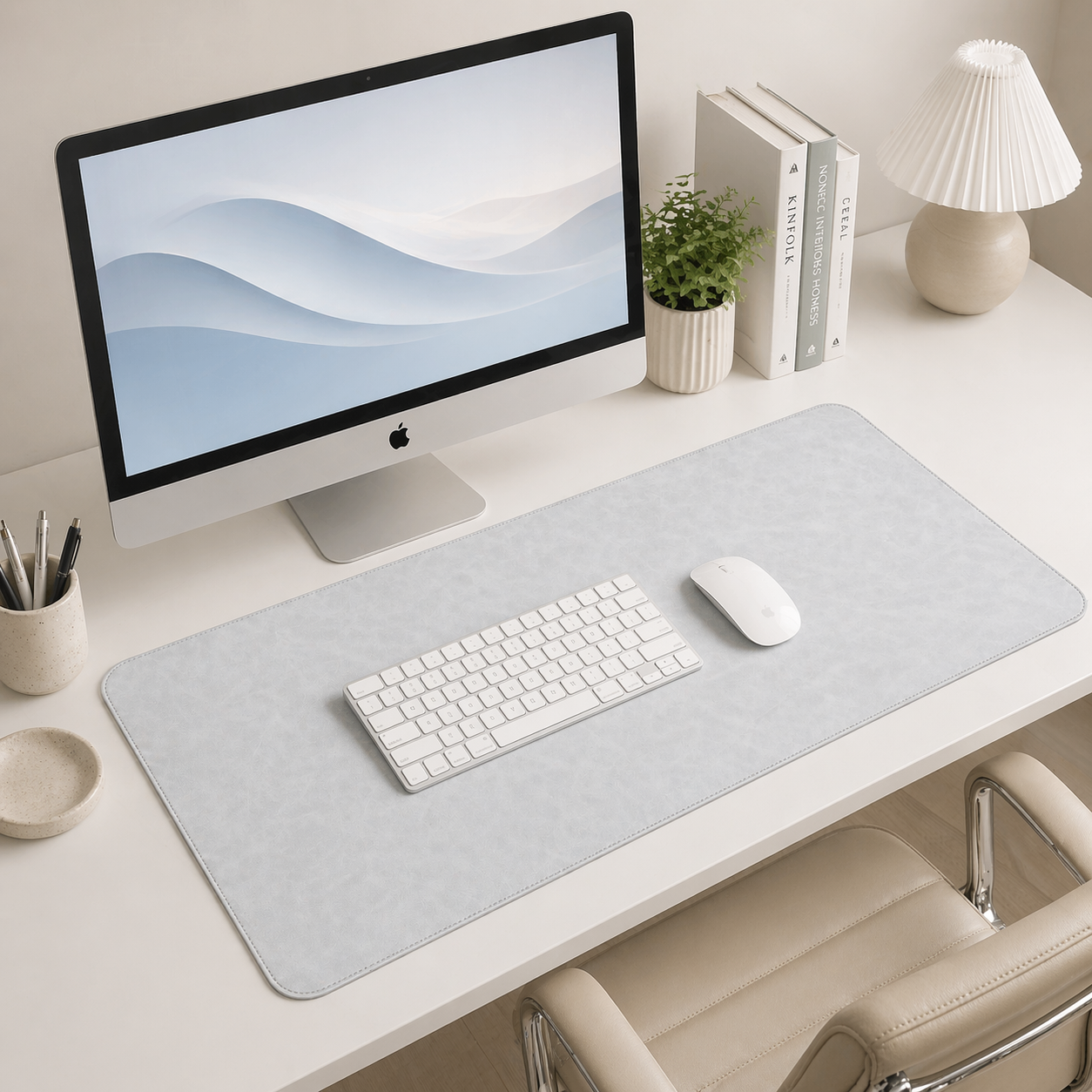 Modern office desk setup with computer monitor, keyboard, mouse, and decorative items.