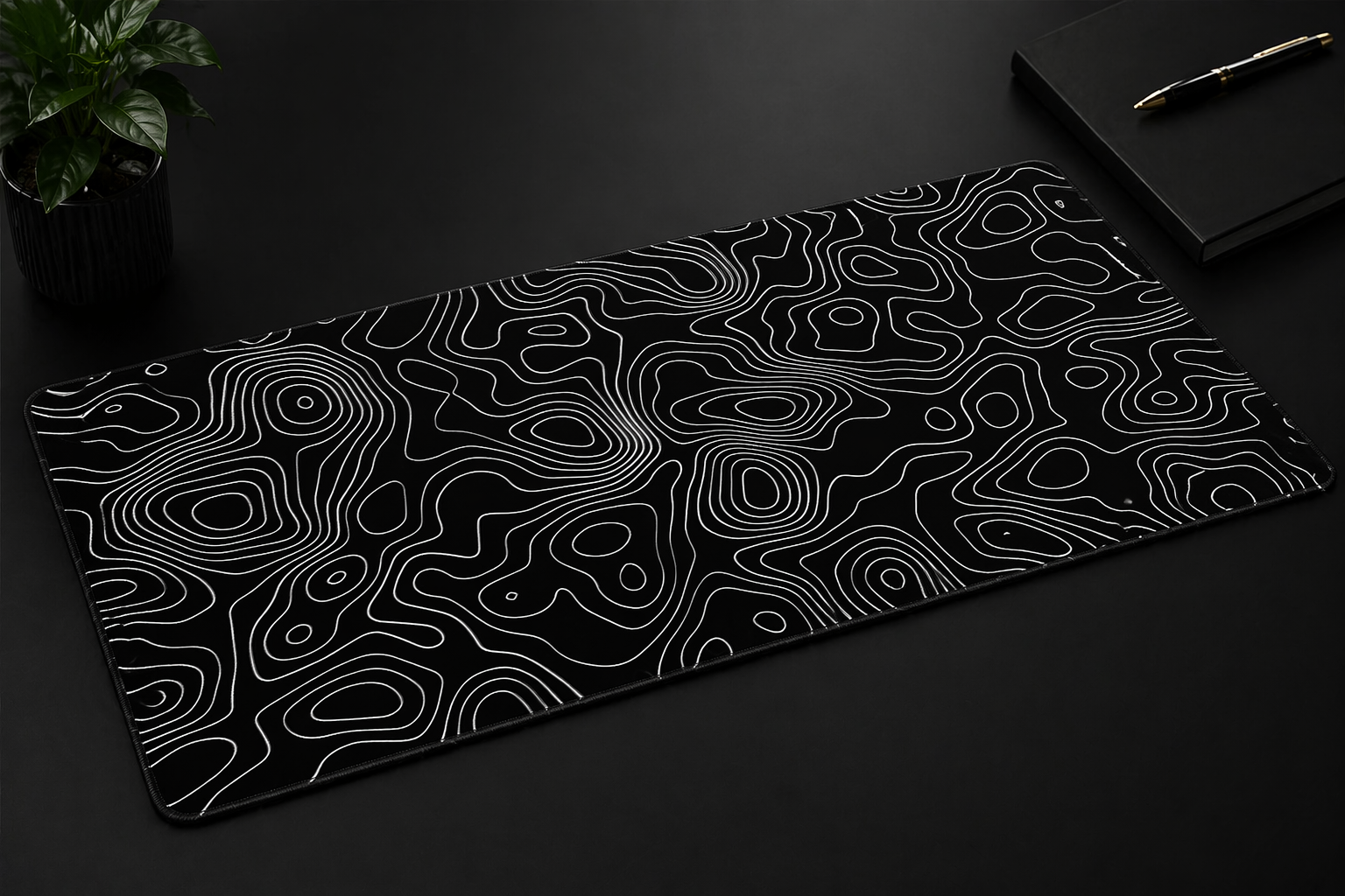 Black desk mat with white wavy line pattern on a dark surface
