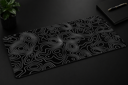 Black desk mat with white wavy line pattern on a dark surface