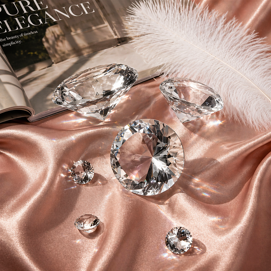 Diamonds on a pink satin surface with feathers and a magazine in the background