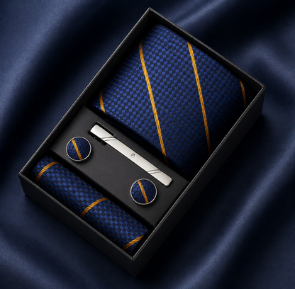 Set of blue tie, cufflinks, and tie clip in a black box on a dark fabric background