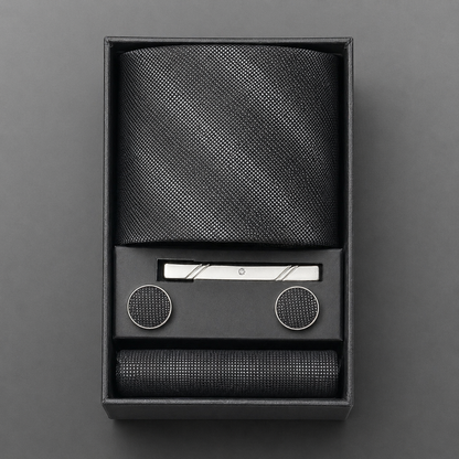 Black textured tie set with tie bar and tie clips in a box on a gray background
