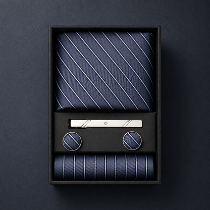 Navy striped tie set with tie clip and pocket square in a black box on a dark background