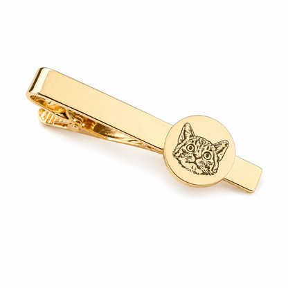 Gold tie clip with cat design on a white background
