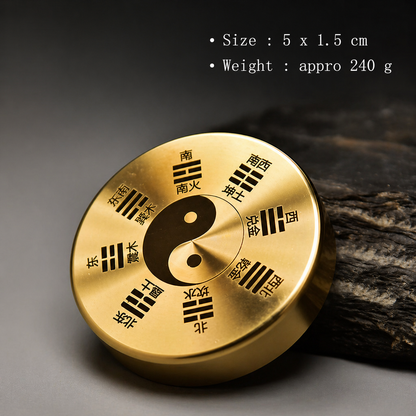 Gold circular object with Chinese characters and a yin-yang symbol on a dark background