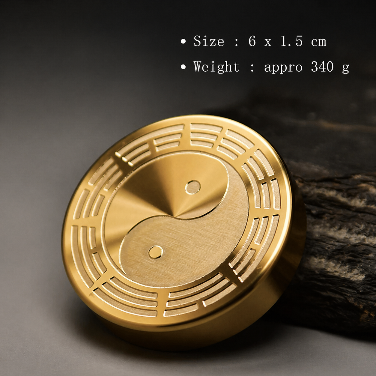 Gold circular object with yin-yang design on a dark background