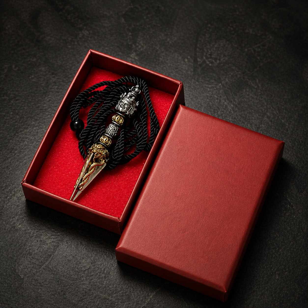 Decorative brooch with intricate design in a red box on a dark surface