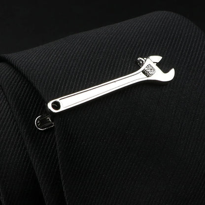 Metallic adjustable wrench keychain on a black textured background