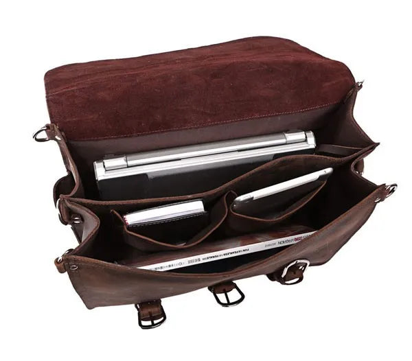 Brown leather bag with compartments and silver items inside on a white background