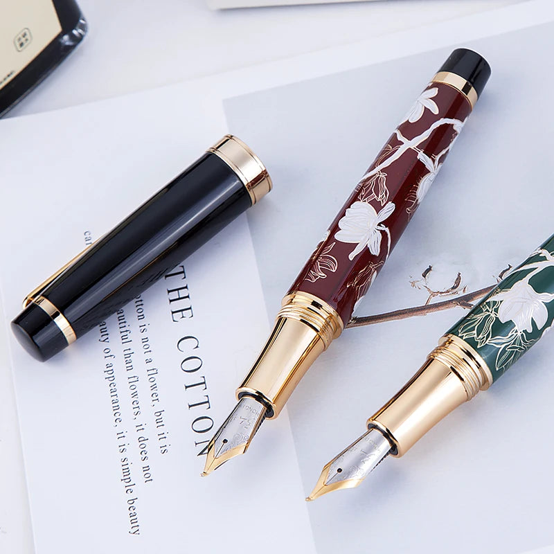 Two fountain pens with floral designs on a white surface