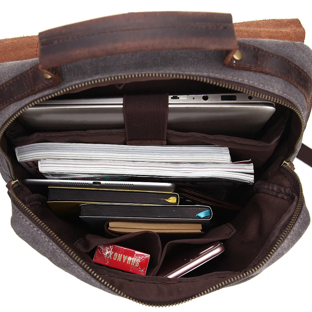 Brown leather bag with compartments containing electronic devices and papers on a white background