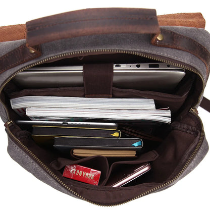 Brown leather bag with compartments containing electronic devices and papers on a white background