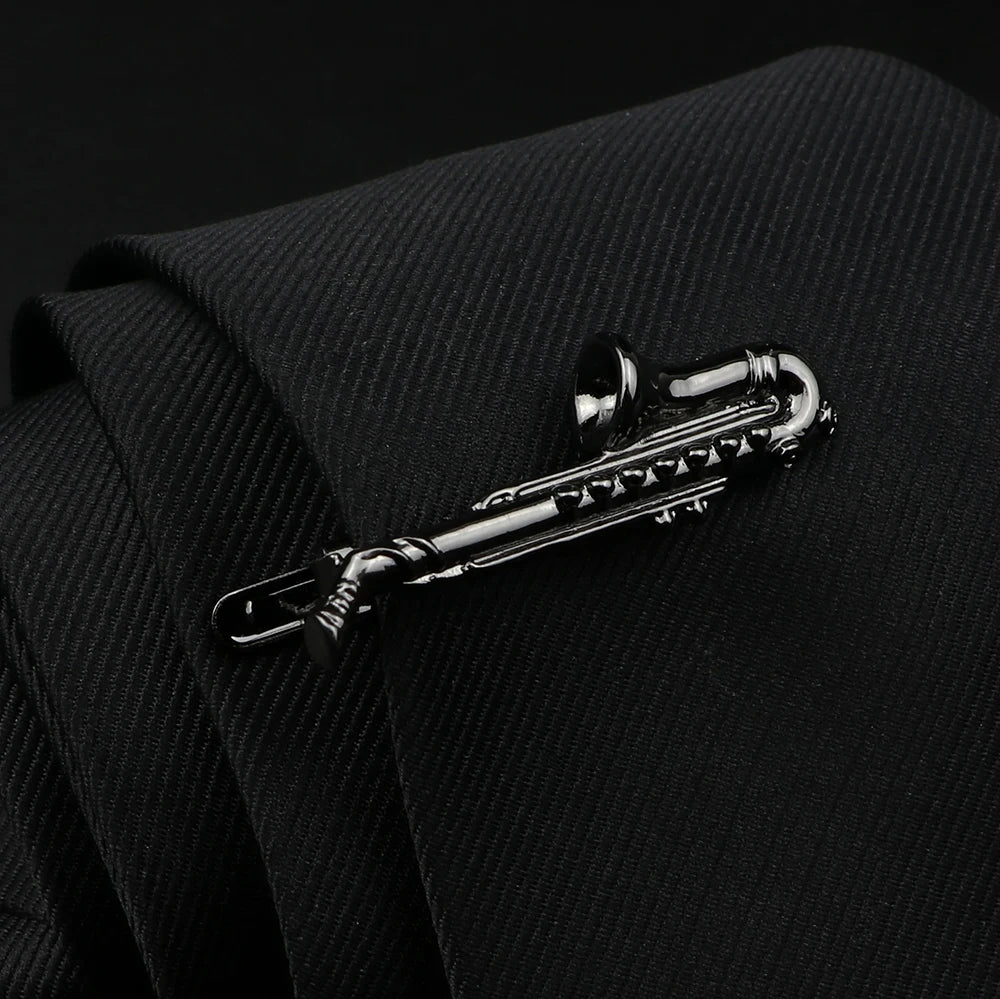 Silver saxophone tie clip on a black suit background