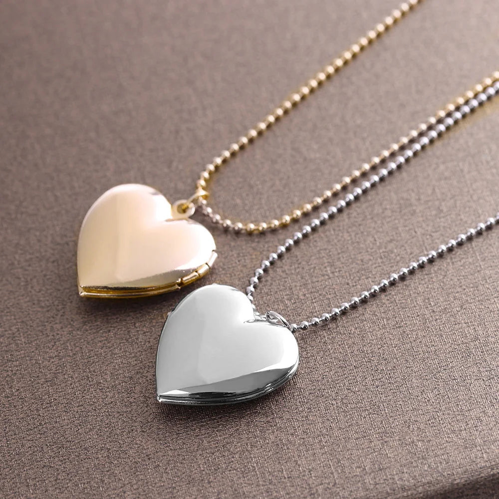 Two heart-shaped locket necklaces on a brown surface