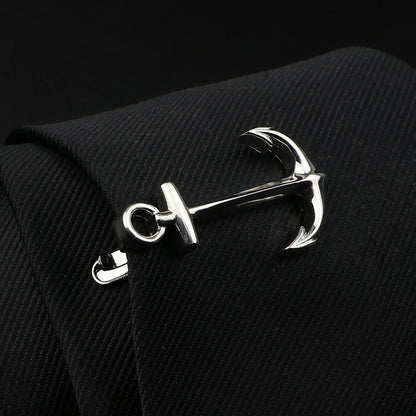 Silver anchor-shaped cufflink on a black textured fabric background