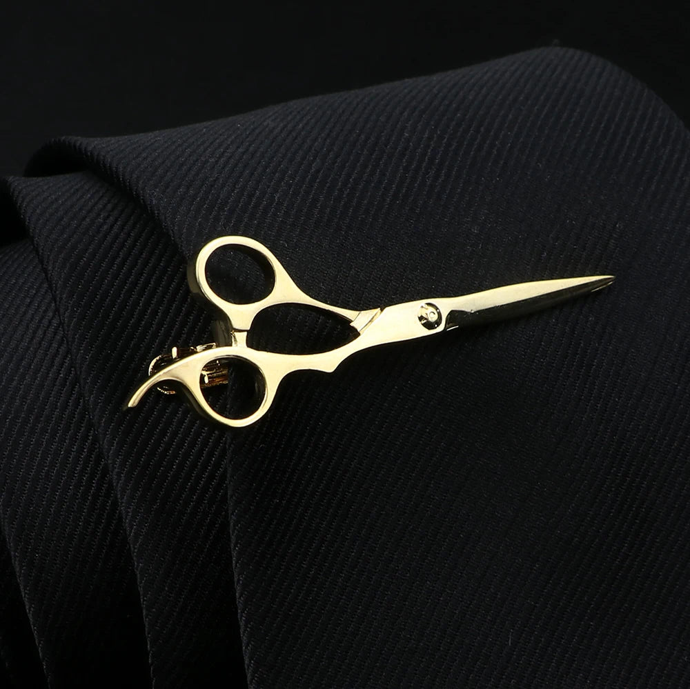 Gold scissors on a black textured fabric background