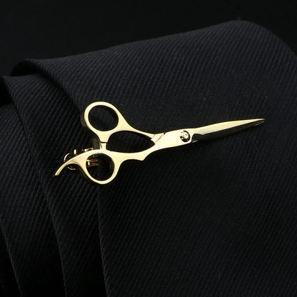 Gold scissors on a black textured fabric background