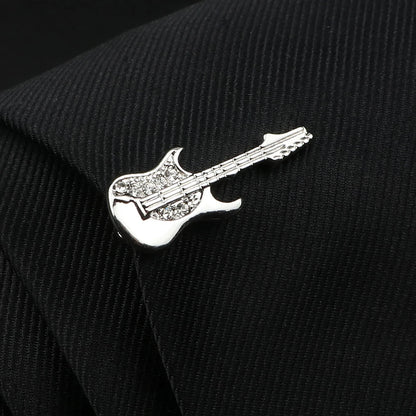 Silver guitar-shaped pin on a black textured fabric background