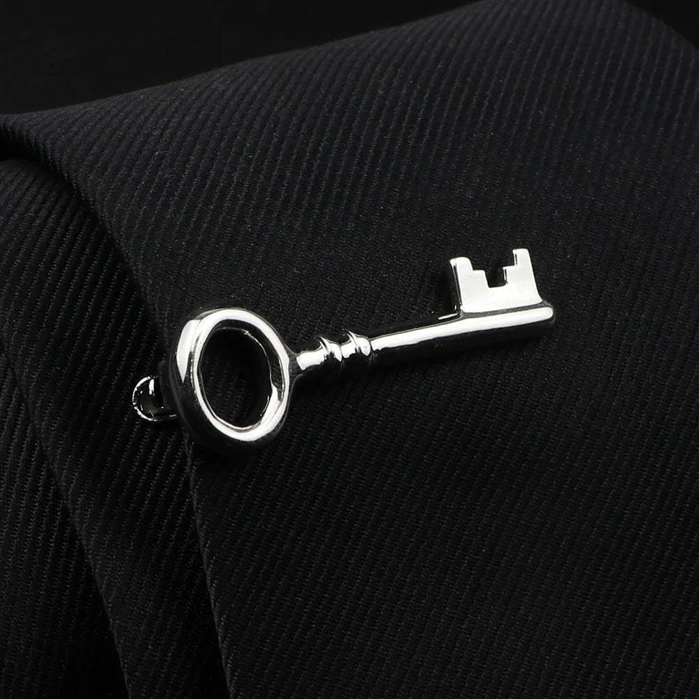 Silver key-shaped cufflink on a black suit jacket