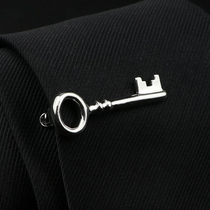 Silver key-shaped cufflink on a black suit jacket