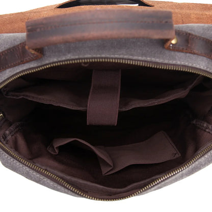 Open brown leather bag with gray interior showing a strap