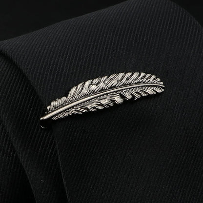 Silver feather-shaped lapel pin on a black suit jacket