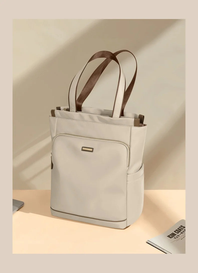 Beige tote bag with brown straps on a light beige background