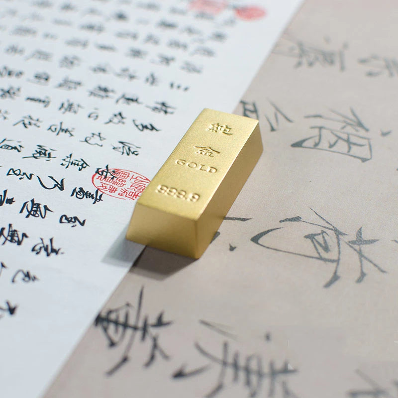 Gold bar on top of a piece of paper with Chinese text