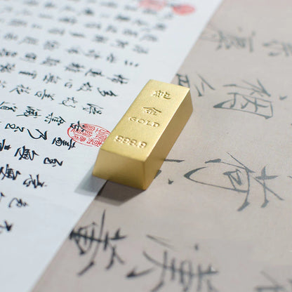 Gold bar on top of a piece of paper with Chinese text