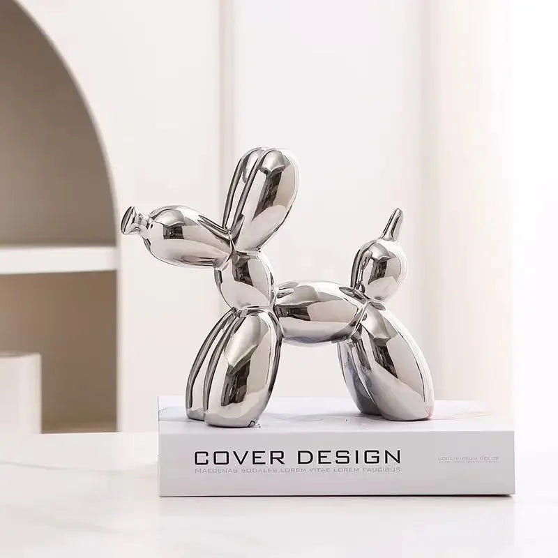 Silver dog-shaped decorative object on a white surface with a neutral background