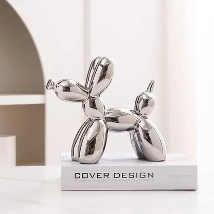 Silver dog-shaped decorative object on a white surface with a neutral background
