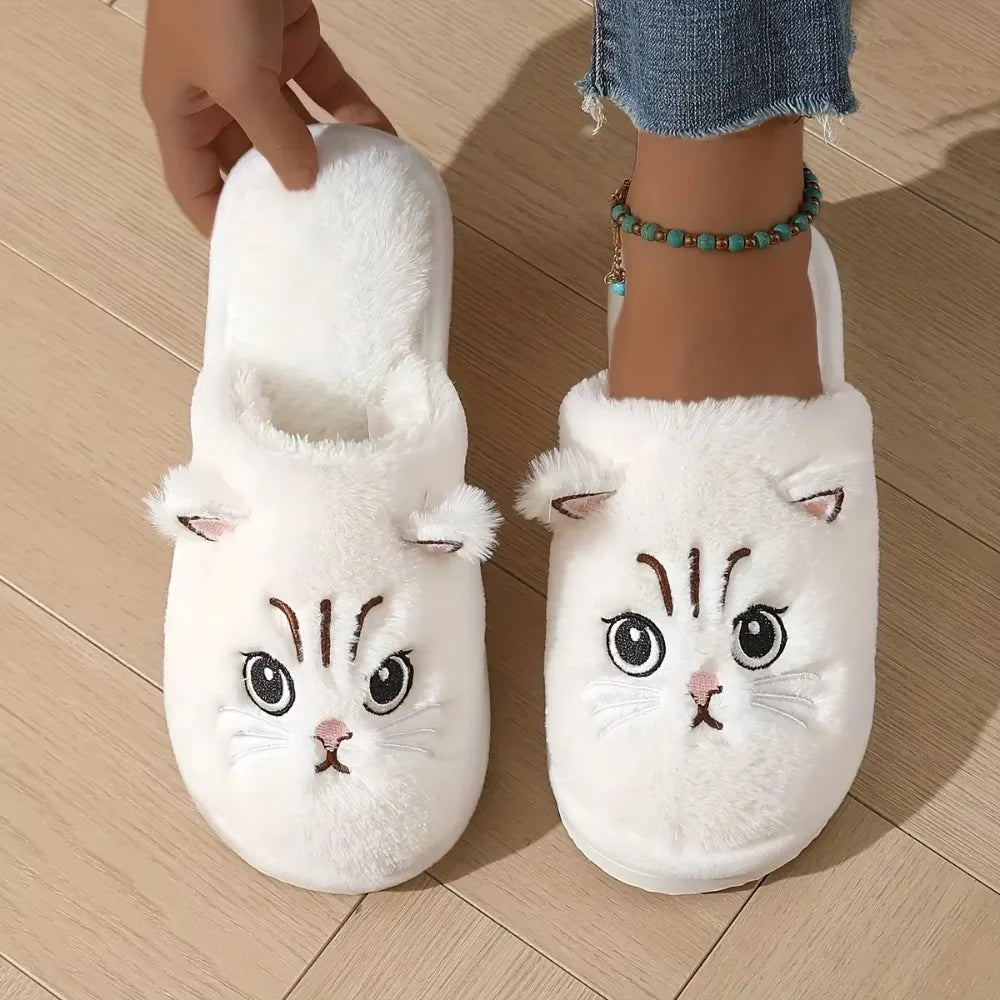 White cat-shaped slippers on a wooden floor