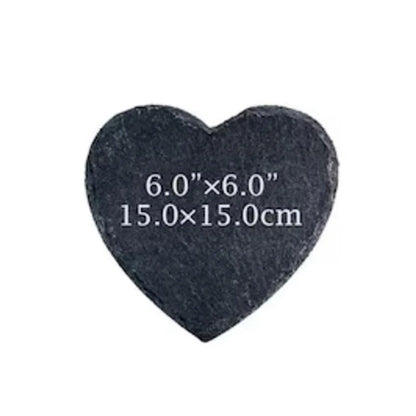 Heart-shaped black stone with measurements on a white background
