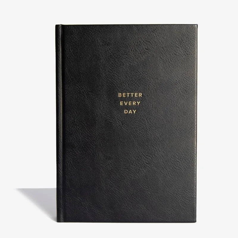 Black notebook with 'Better Every Day' text on a white background