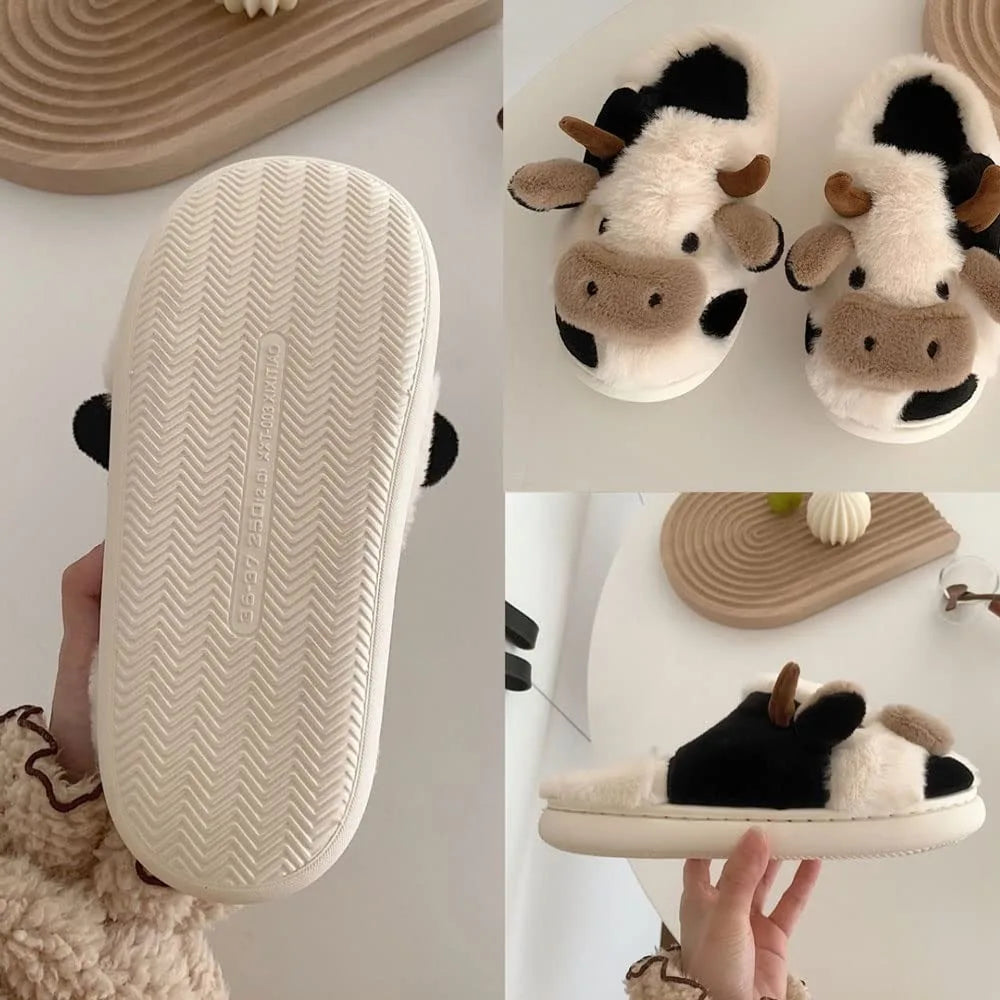 Cow-themed slippers with a textured sole held by a hand, displayed against a neutral background.