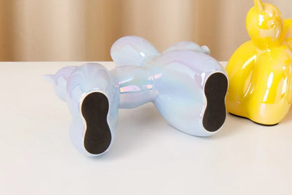 Iridescent unicorn figurine on a white surface with a yellow object in the background