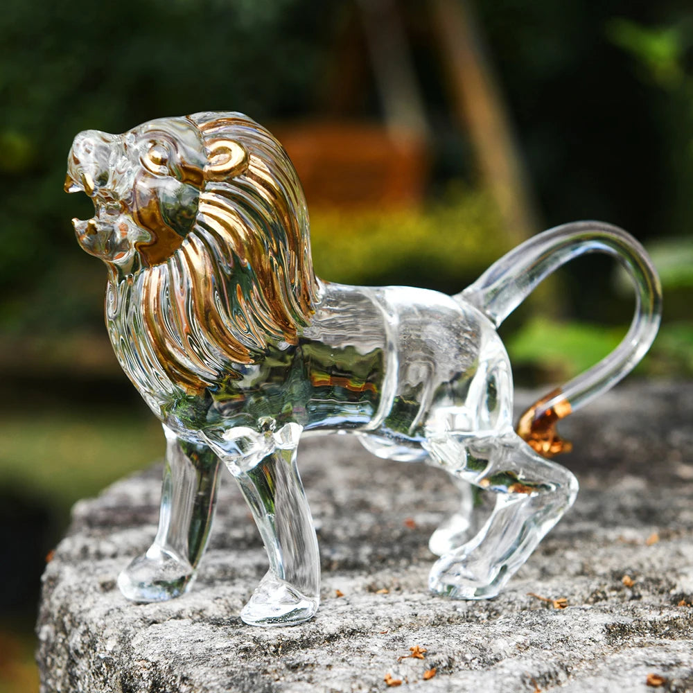 Clear glass lion figurine with gold accents on a stone surface