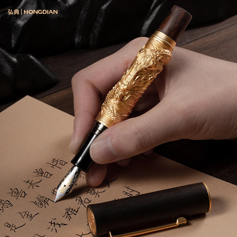 Hand holding a ornate fountain pen with detailed design, writing on a piece of paper.