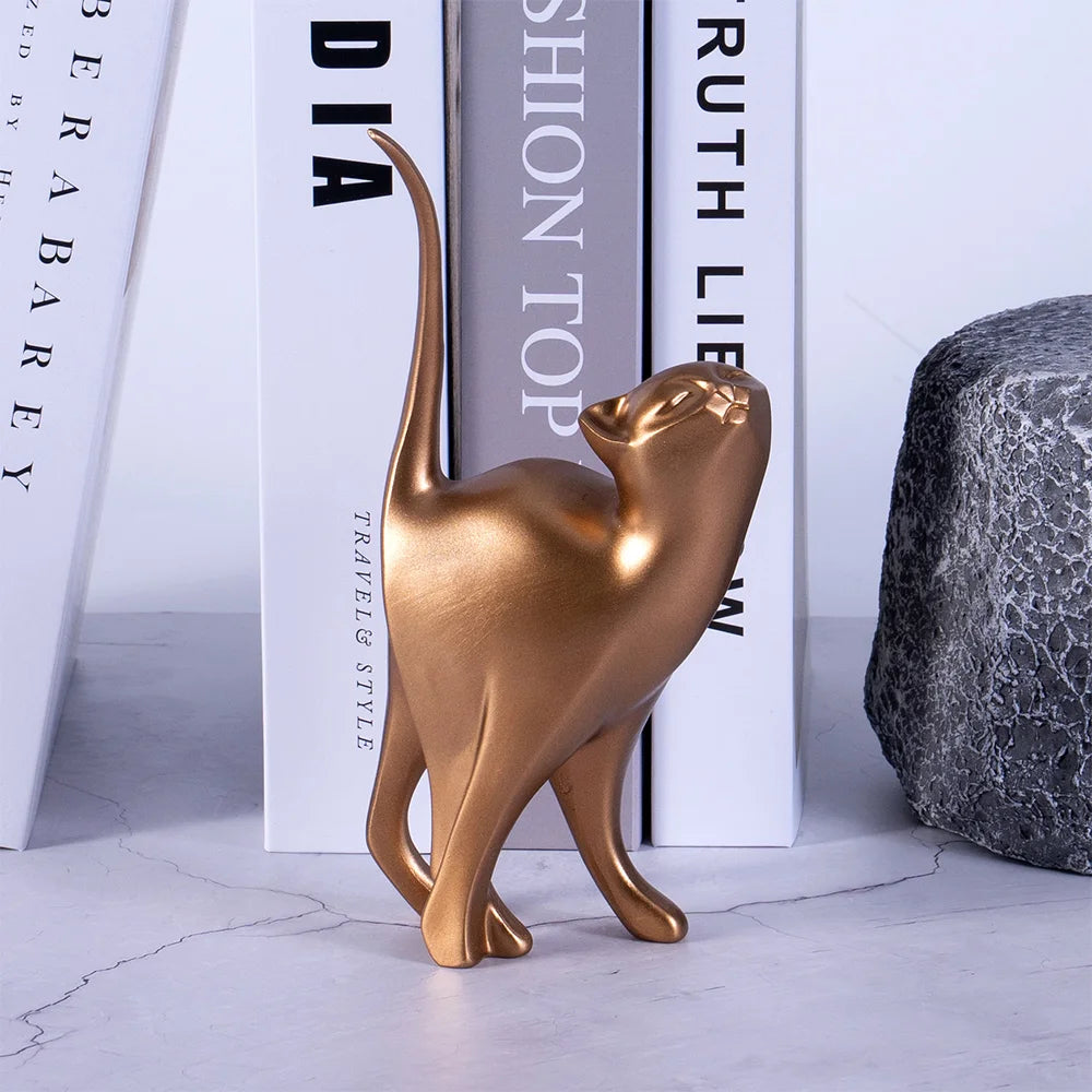 Bronze cat figurine on a marble surface with books in the background