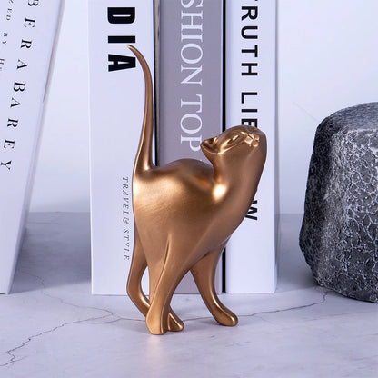 Bronze cat figurine on a marble surface with books in the background