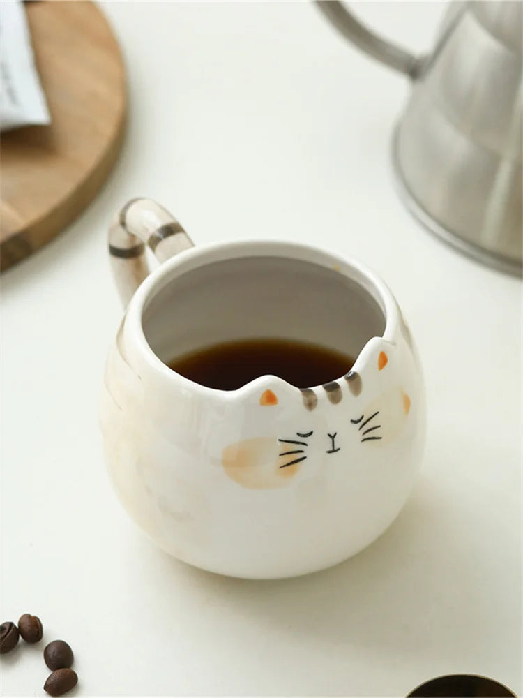 Cat-shaped ceramic mug with coffee on a white surface