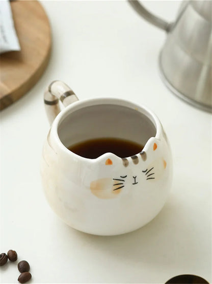 Cat-shaped ceramic mug with coffee on a white surface