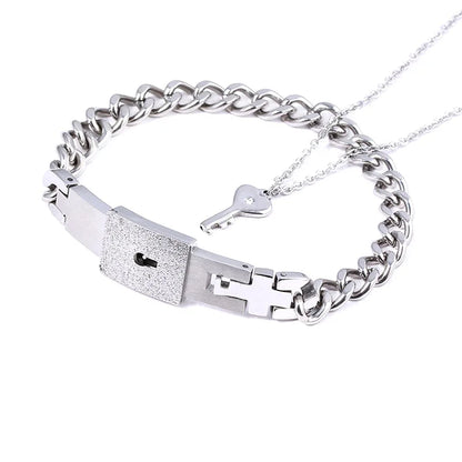 Silver chain bracelet with key and lock charm on a white background