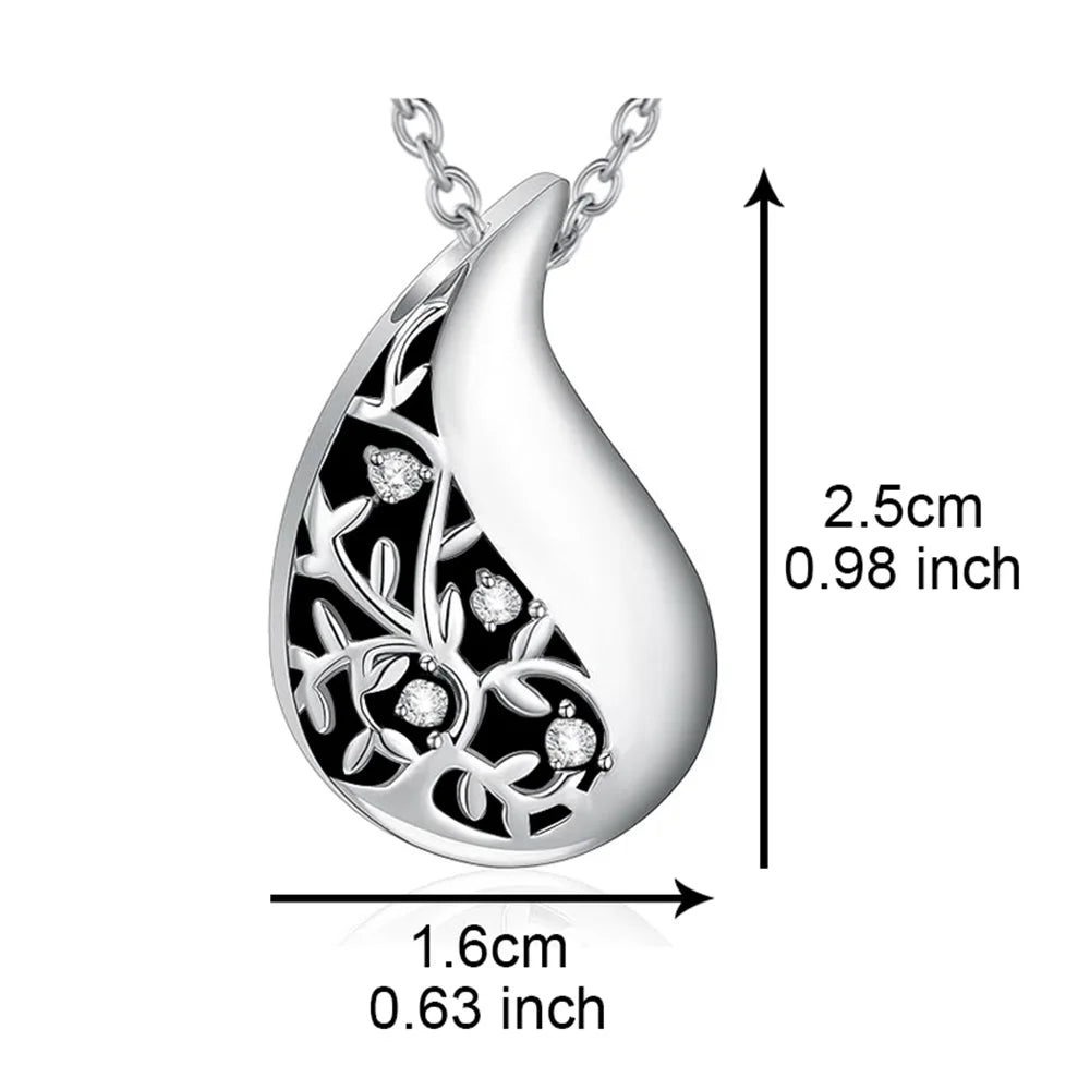 Silver teardrop-shaped pendant with floral design and measurements on a white background